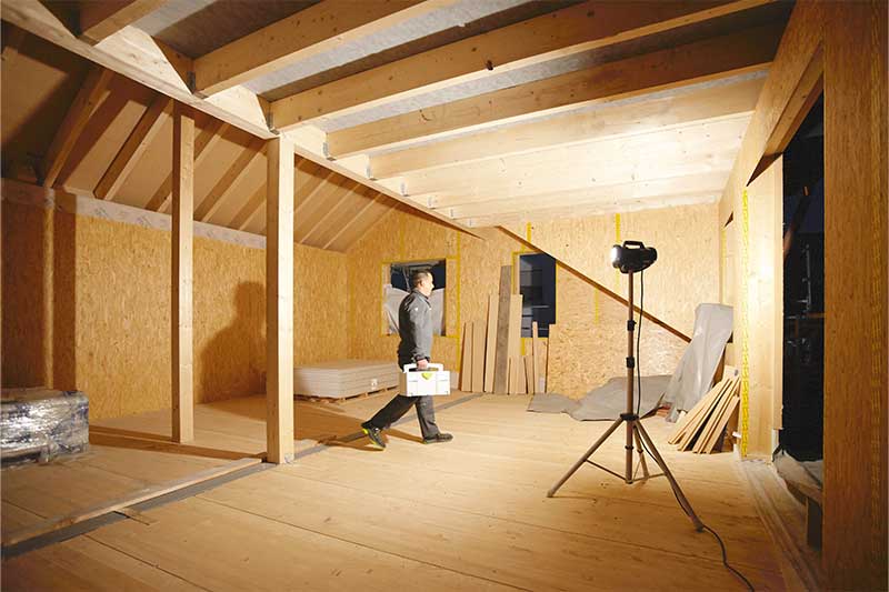 Egy munkalámpa megvilágít egy ablaktalan, sötét helyiséget.