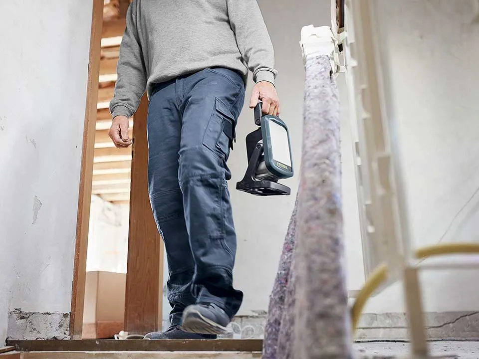 Egy mesterember munkalámpát hordoz...